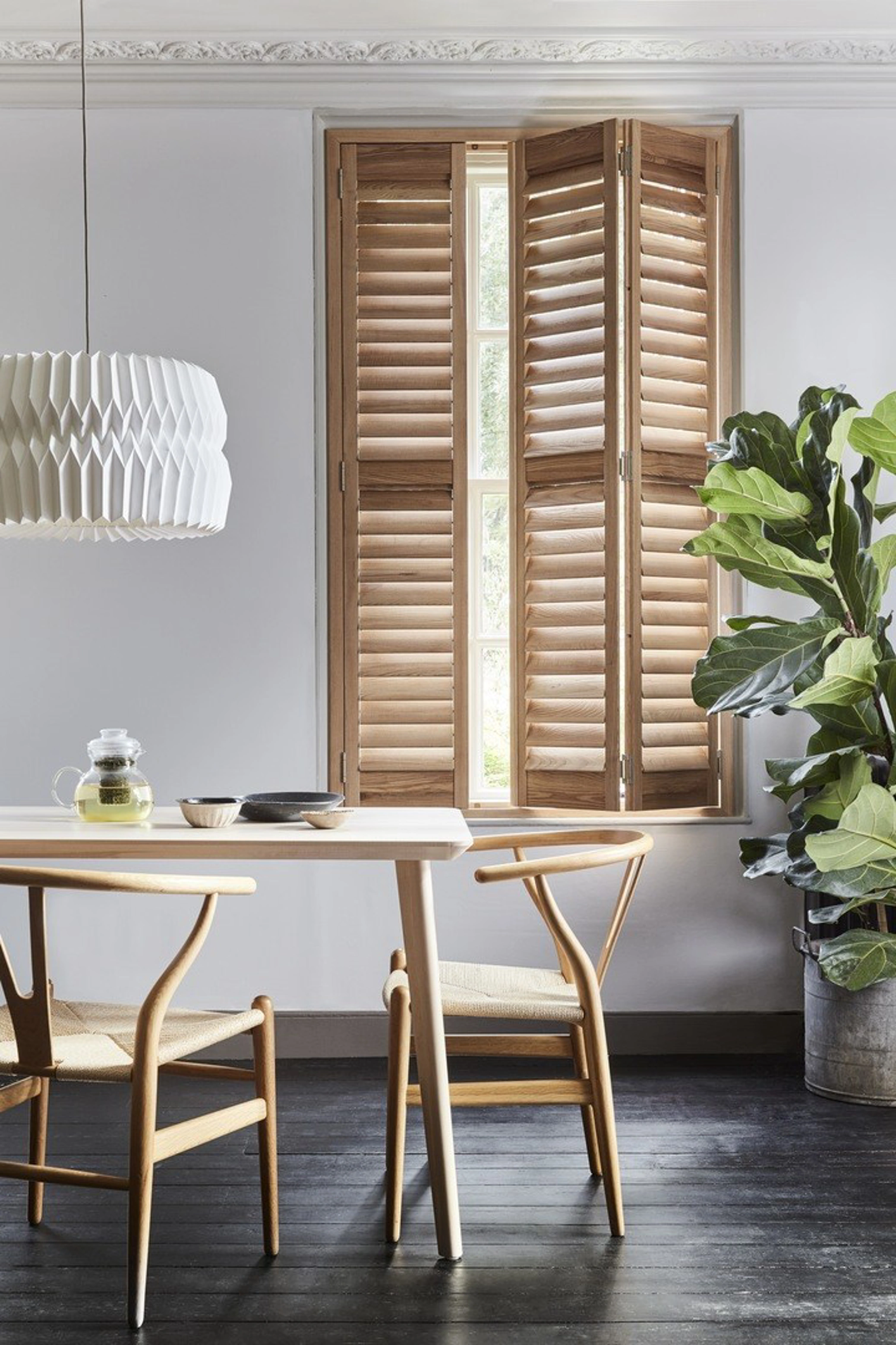 Honey Stained wooden full height shutters in dining room