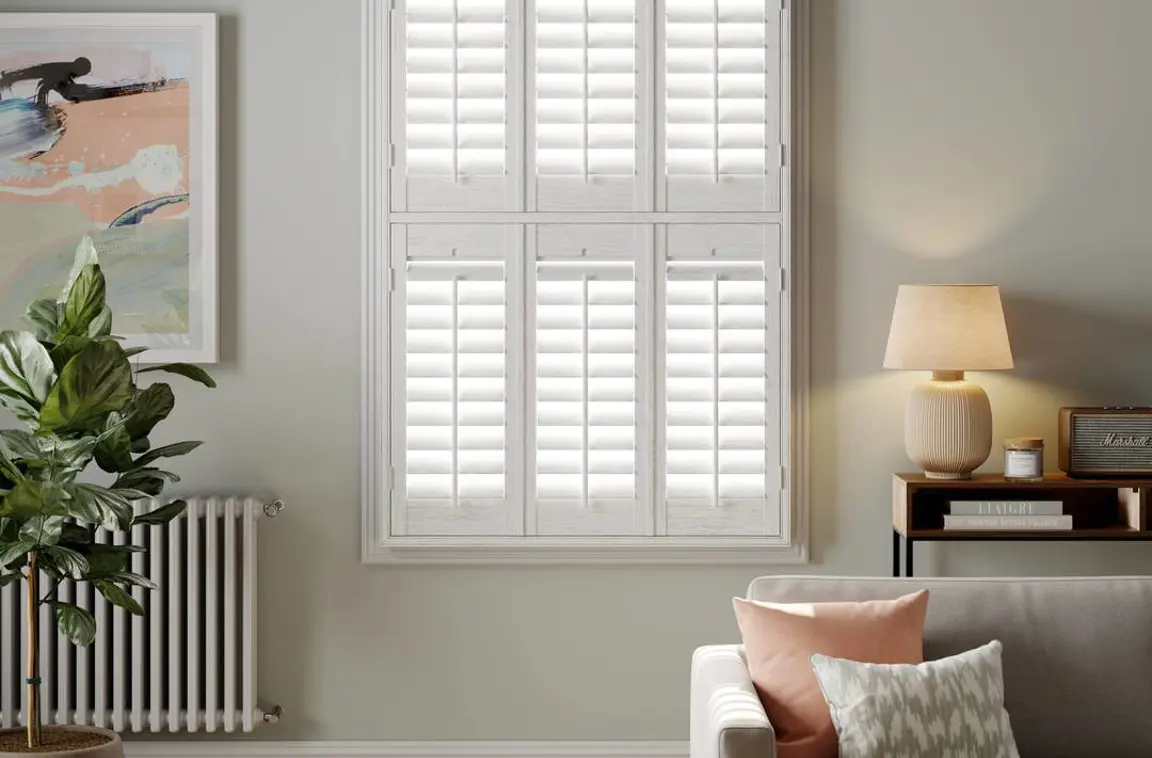 White Grained wooden shutters on light grey wall in living room