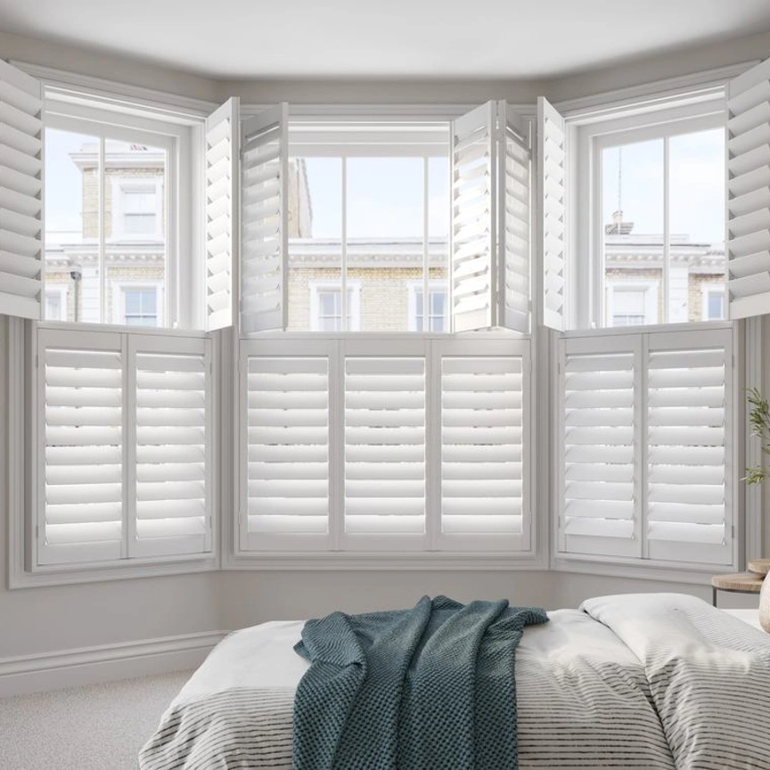 Vivid White bay window wooden shutters in neutral bedroom
