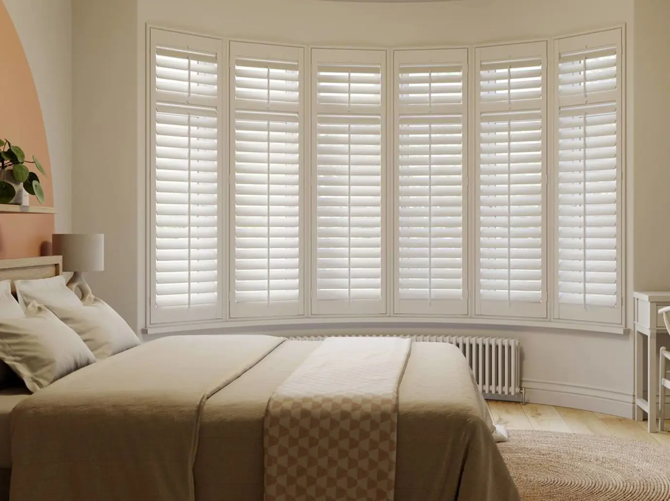 Vivid White wooden shutters in a curved bay and neutral bedroom