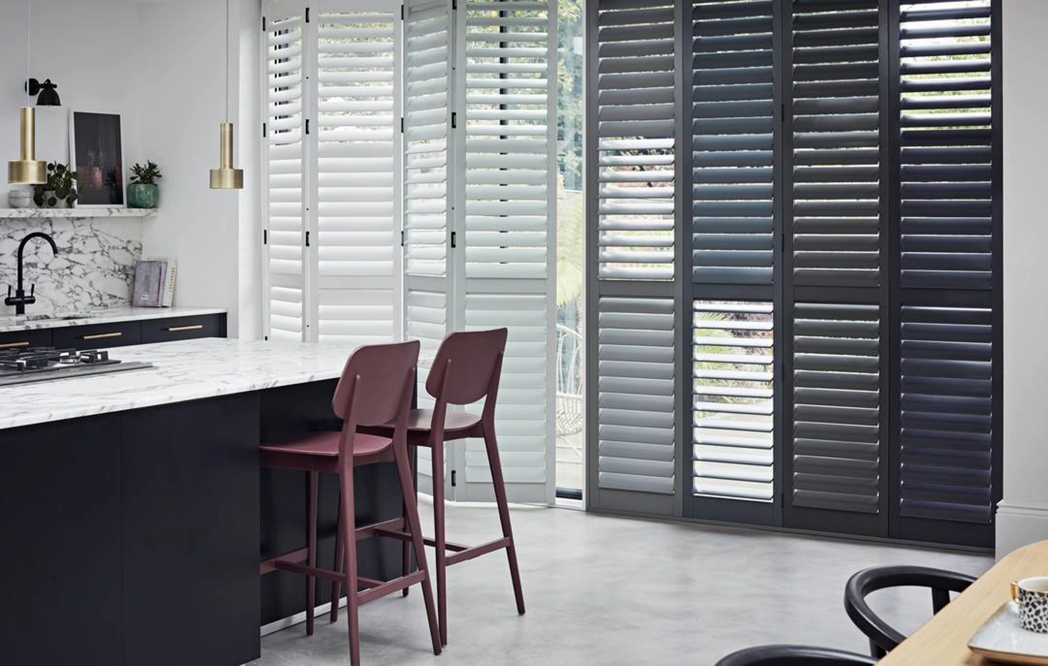 Sliding patio doors with white and grey wooden shutters in kitchen