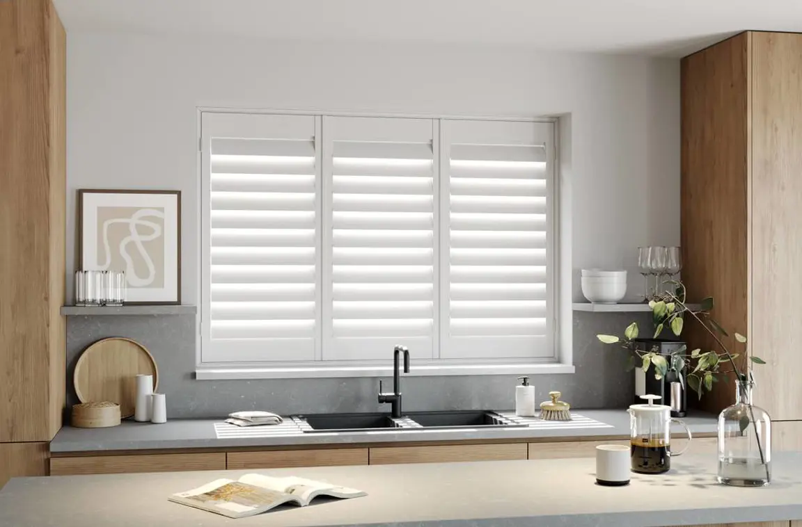 A modern kitchen with Traffic White full height wooden shutters 