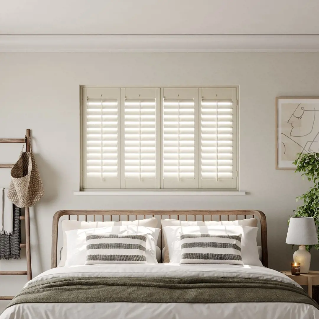 A modern neutral bedroom with Cream full height wooden shutters