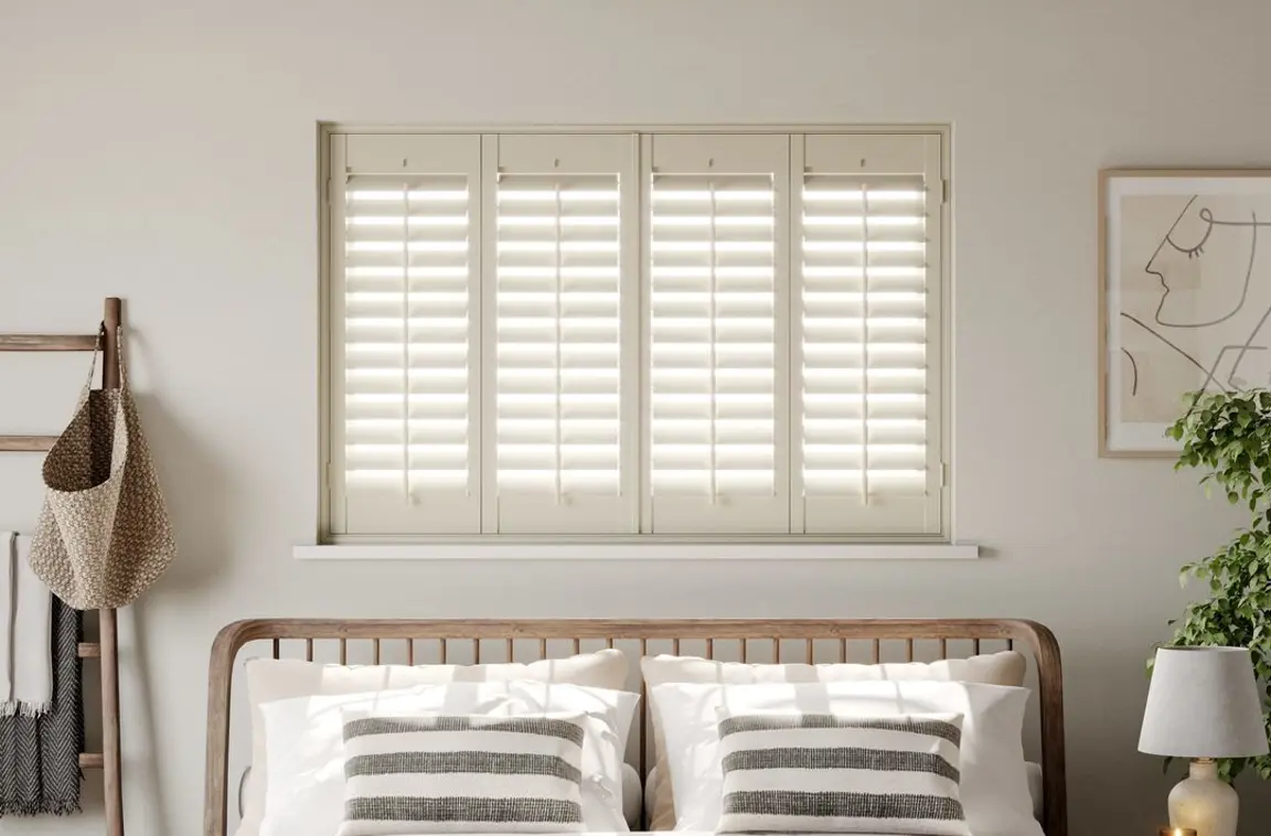 A modern neutral bedroom with Cream full height wooden shutters