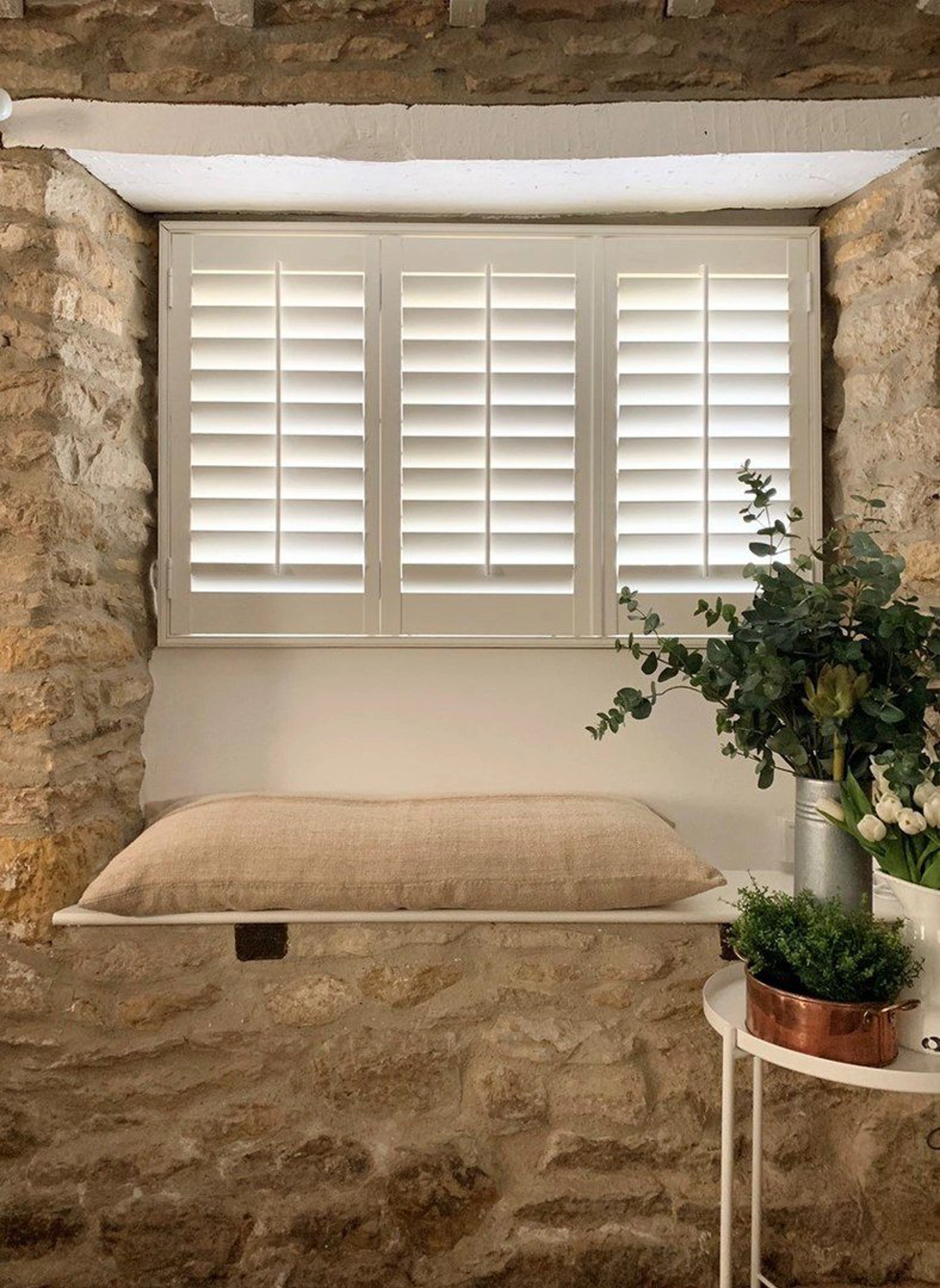 Traffic White wooden shutters in stone wall cottage