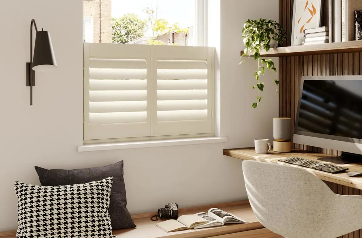 Cream wooden window shutters in home office