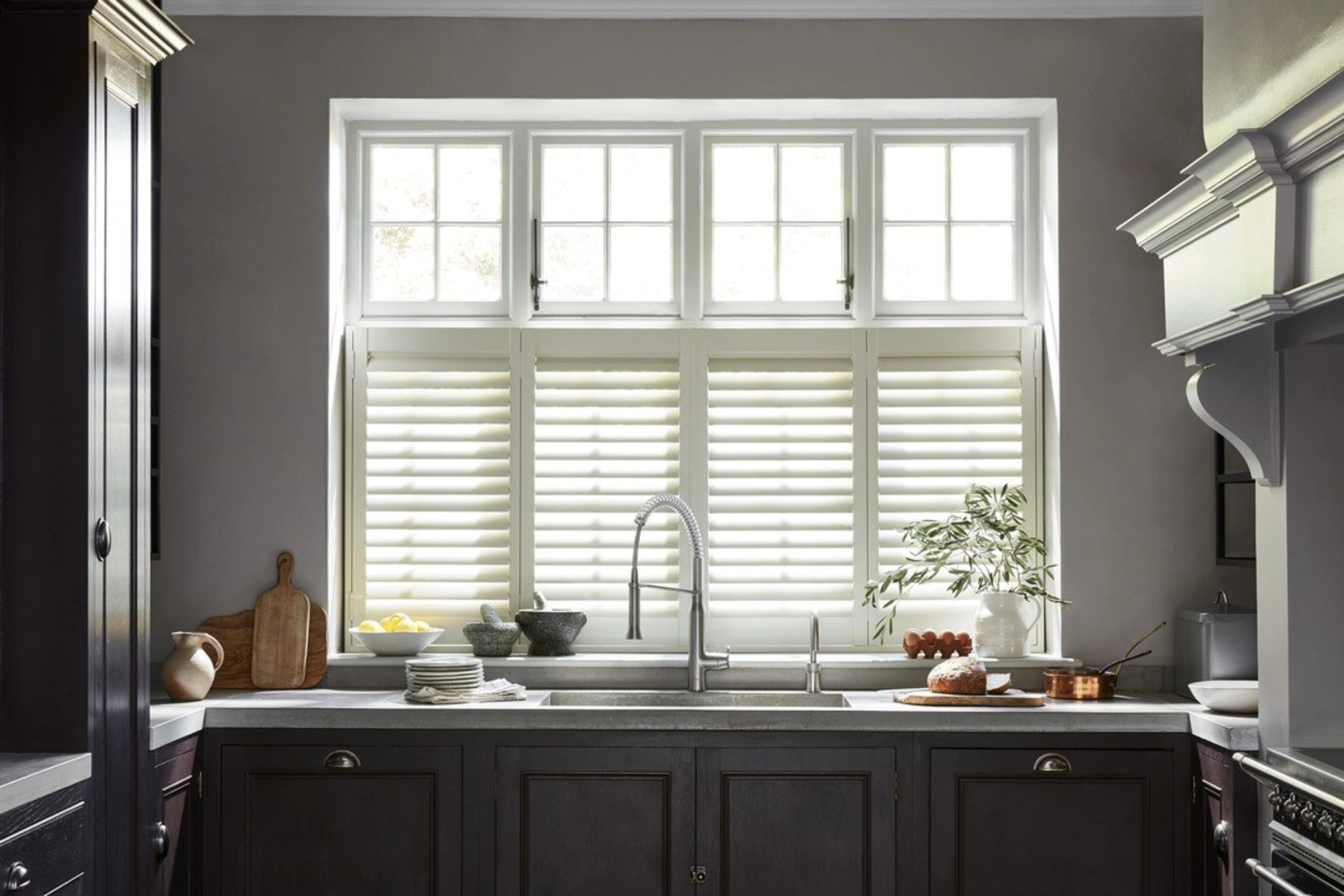 Cream cafe style shutters in black traditional kitchen