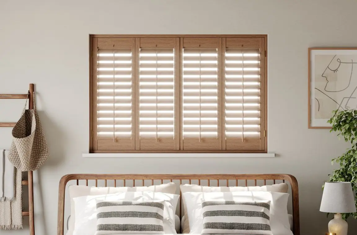 Honey Stained wooden shutters above neutral bed