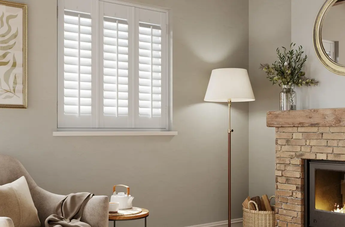 A cottage style living room with Snow White full height faux wood shutters 