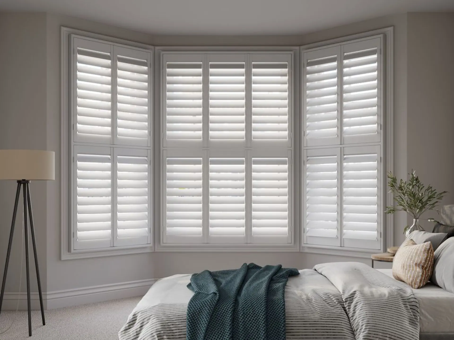 White bay wooden shutters in neutral bedroom