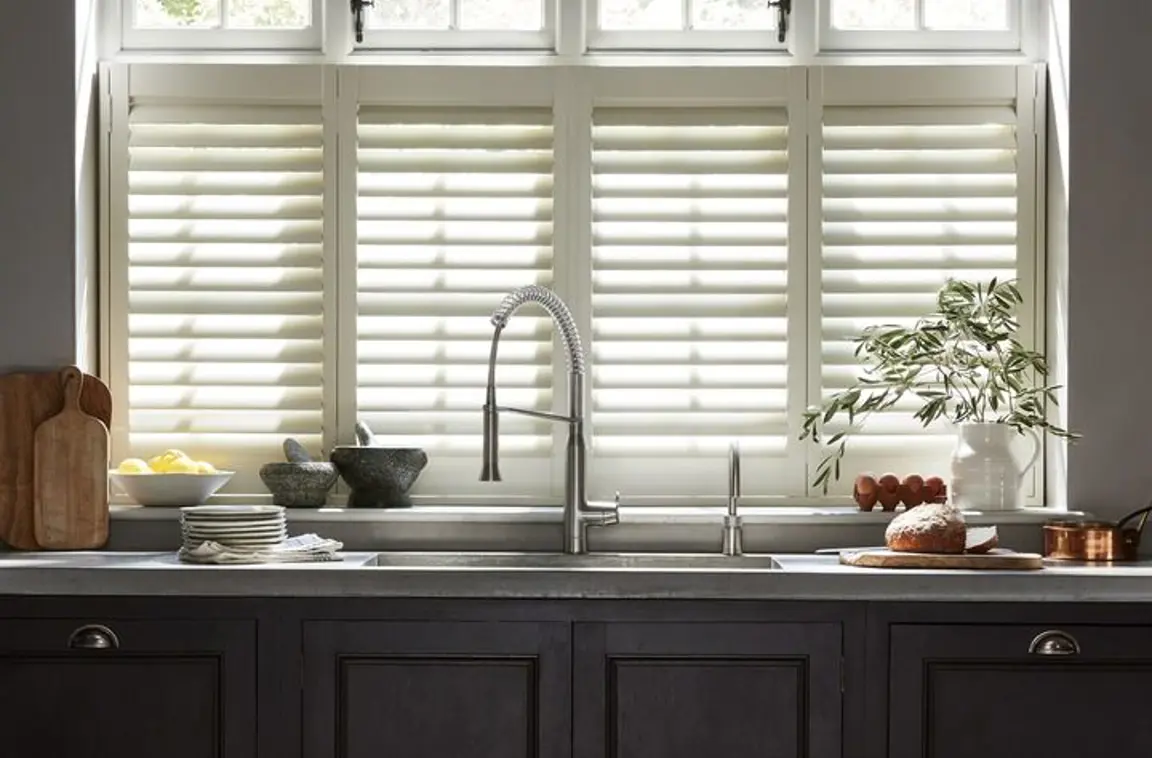 Cream wooden shutters in dark grey traditional kitchen