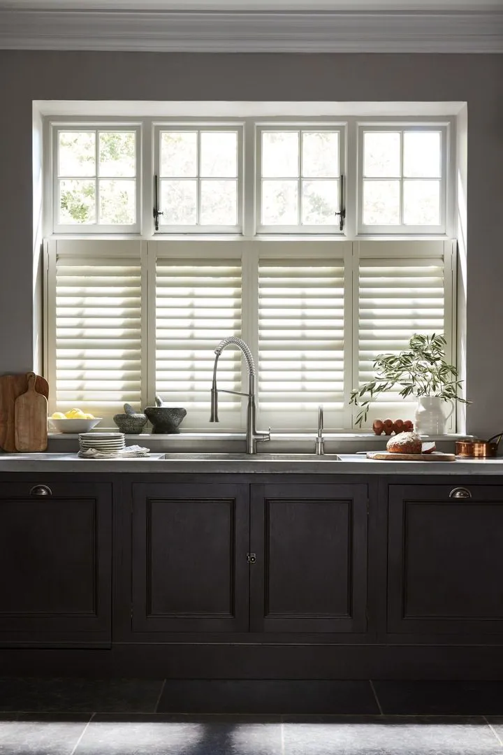 Cream wooden shutters in dark grey traditional kitchen