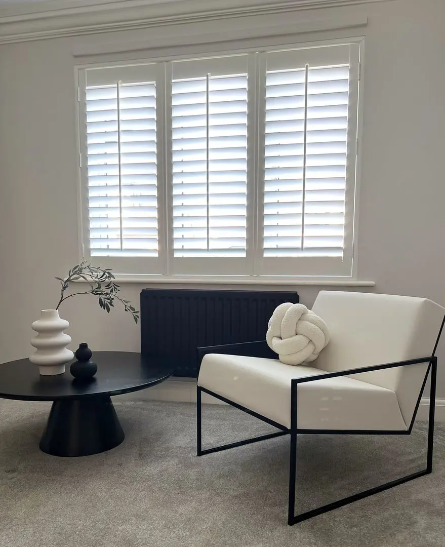 Snow White faux wood shutters with cream and black armchair