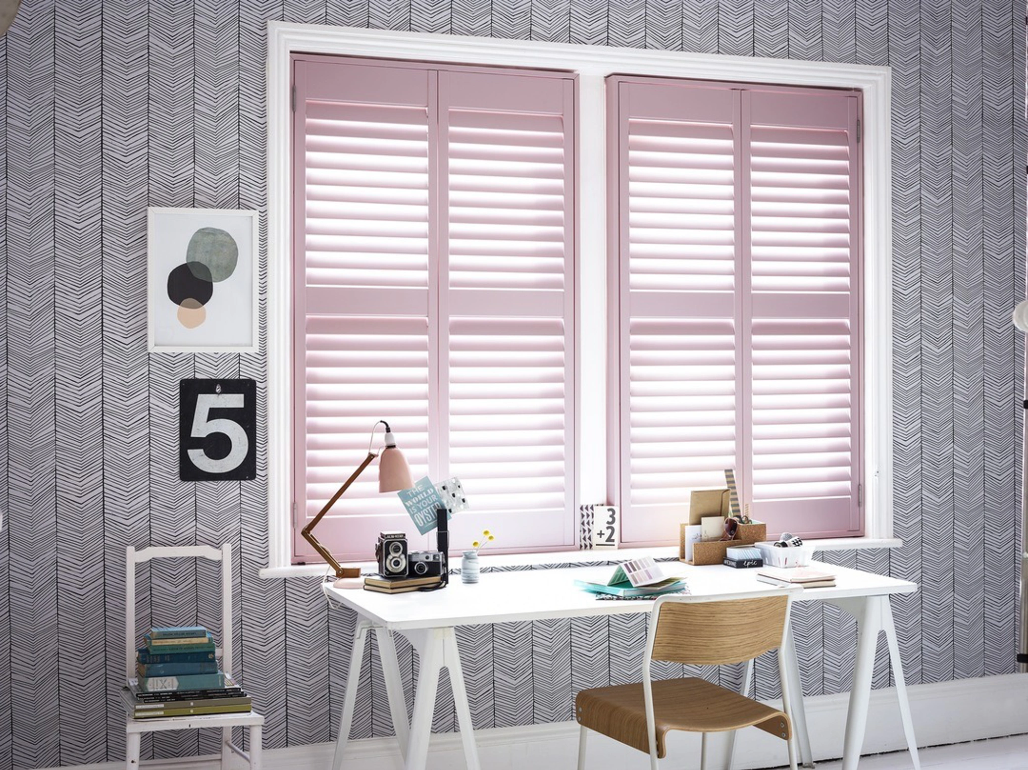 Full height pink wooden shutters in home office
