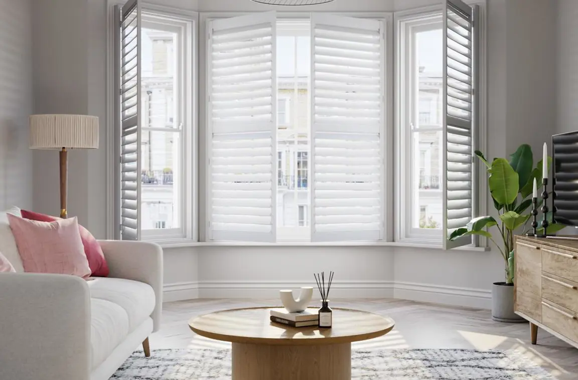 Vivid White wooden bay window shutters with cream sofa