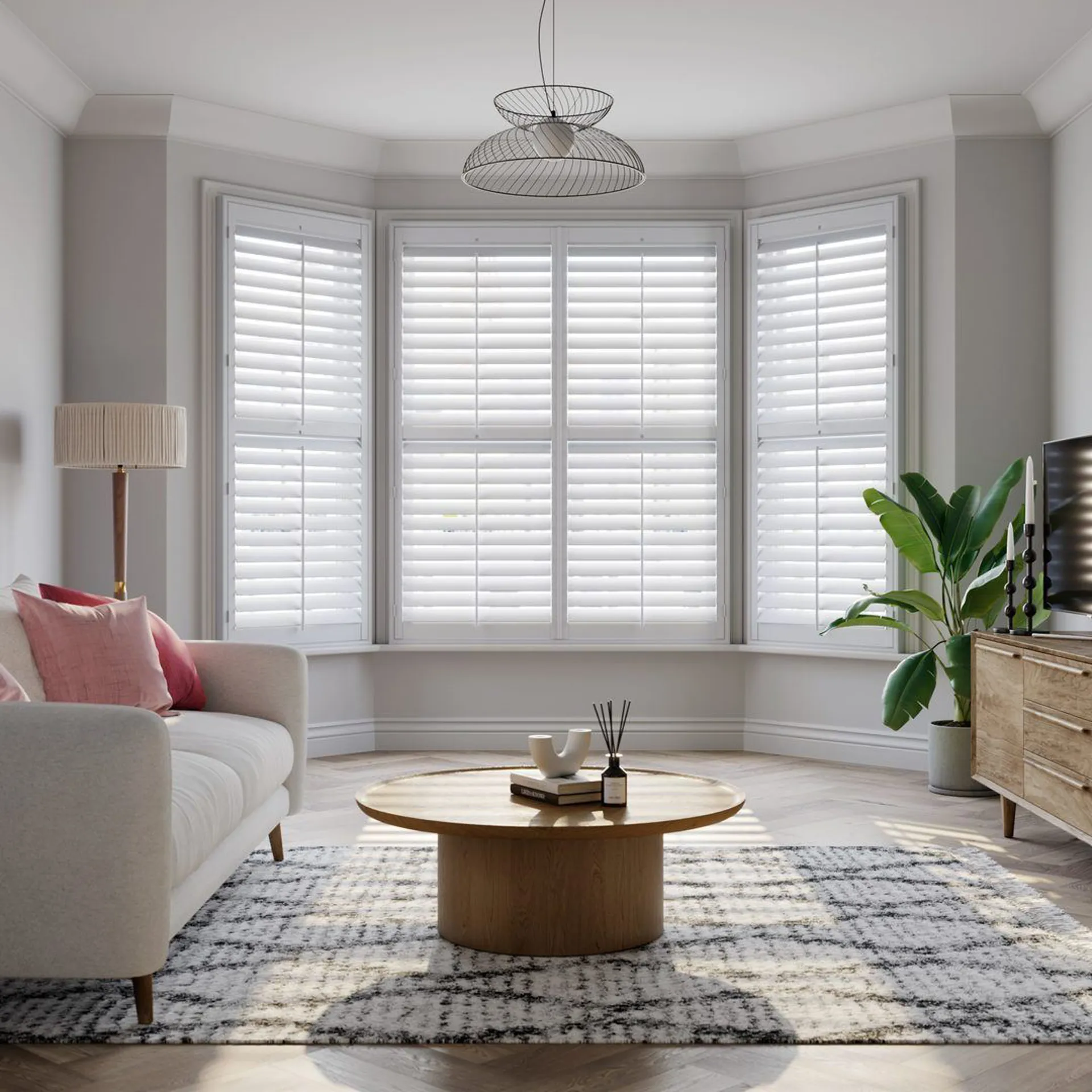 Vivid White splayed bay window shutters with cream sofa 