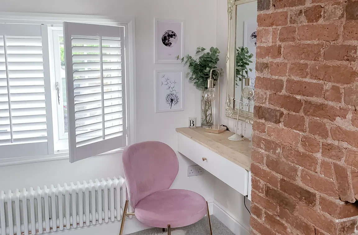 Vivid White wooden shutters in dressing room with pink and gold chair